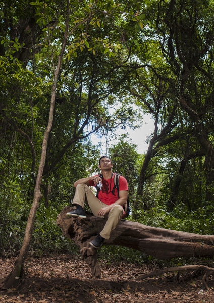 backpacker sitting tree trunk th